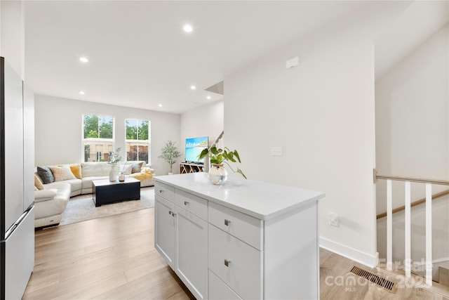 3748 Ellington St, Charlotte, NC 28211 - kitchen with light wood-type flooring, white cabinetry, recessed lighting, a center island, and light countertops