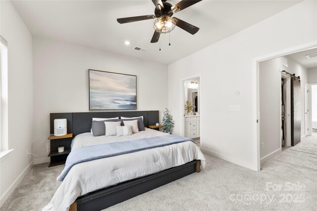 3748 Ellington St, Charlotte, NC 28211 - carpeted bedroom with baseboards, ensuite bathroom, a barn door, and ceiling fan