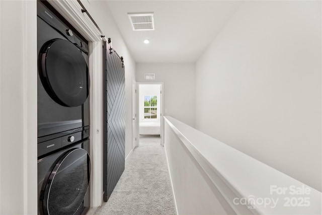 3748 Ellington St, Charlotte, NC 28211 - clothes washing area featuring stacked washer / drying machine, light colored carpet, a barn door, and baseboards