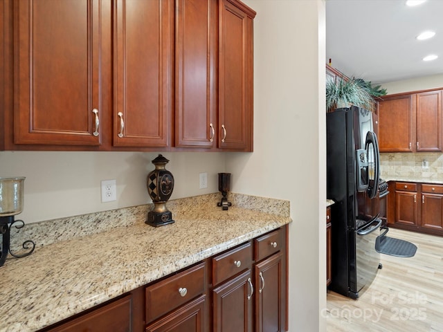 1051 Streamlet Way, Monroe, NC 28110 - kitchen with black fridge with ice dispenser, recessed lighting, light stone countertops, light wood finished floors, and backsplash