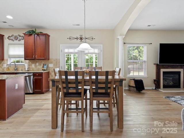 1051 Streamlet Way, Monroe, NC 28110 - dining space featuring plenty of natural light, light wood-type flooring, a glass covered fireplace, and recessed lighting