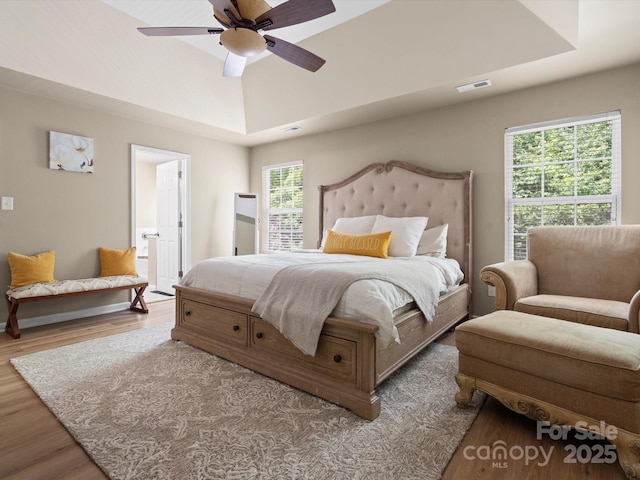 1051 Streamlet Way, Monroe, NC 28110 - bedroom with wood finished floors, a tray ceiling, a ceiling fan, and connected bathroom