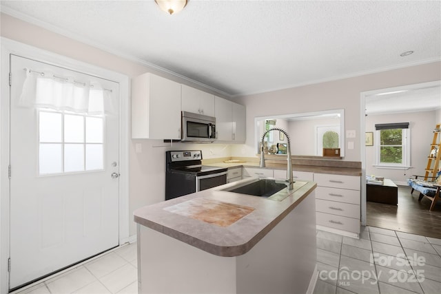 485 Lincoln St, Cramerton, NC 28032 - kitchen with range with electric stovetop, stainless steel microwave, a sink, crown molding, and a kitchen island with sink