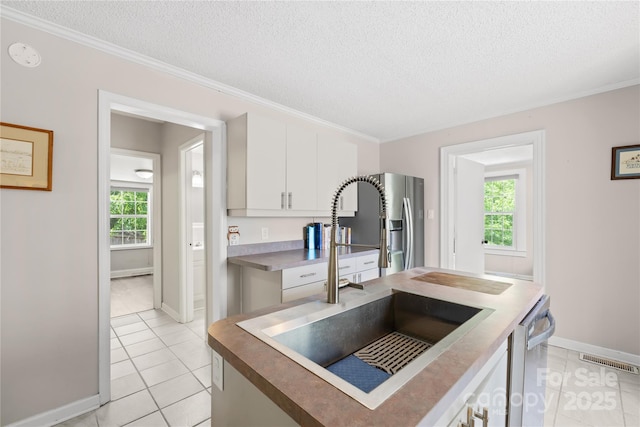 485 Lincoln St, Cramerton, NC 28032 - kitchen featuring a sink, light tile patterned floors, a textured ceiling, white cabinetry, and baseboards