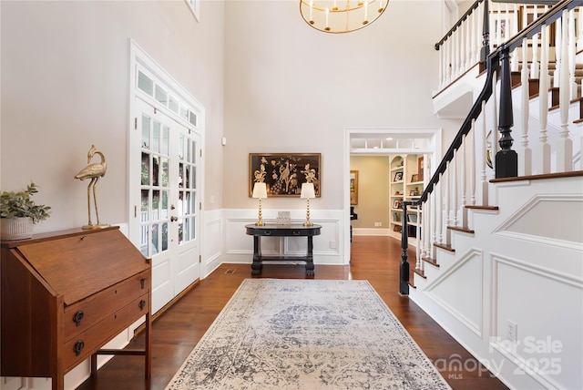 19946 River Falls Dr, Davidson, NC 28036 - entryway featuring french doors, stairs, a high ceiling, dark wood-style flooring, and wainscoting
