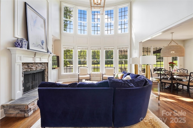 19946 River Falls Dr, Davidson, NC 28036 - living room with a towering ceiling, a stone fireplace, wood finished floors, and baseboards