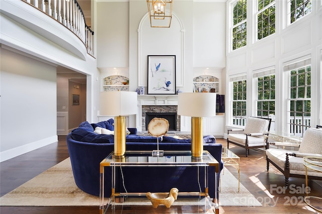 19946 River Falls Dr, Davidson, NC 28036 - living area with a high ceiling, a fireplace, wood finished floors, and baseboards