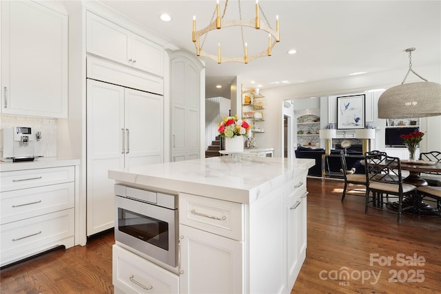 19946 River Falls Dr, Davidson, NC 28036 - kitchen with built in appliances, white cabinets, dark wood-style flooring, hanging light fixtures, and a kitchen island