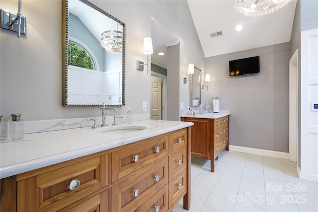 19946 River Falls Dr, Davidson, NC 28036 - bathroom with lofted ceiling, two vanities, marble finish floors, and baseboards