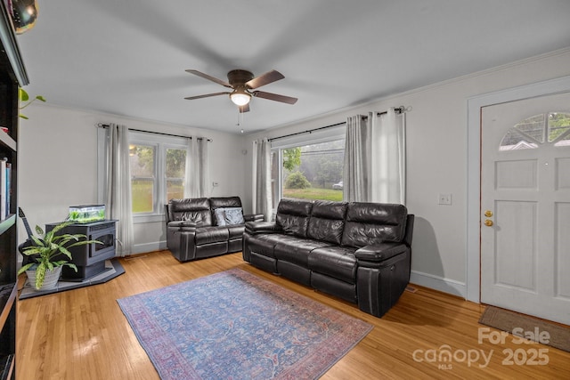 363 High St, Polkton, NC 28135 - living room with a wood stove, ceiling fan, light wood finished floors, and baseboards