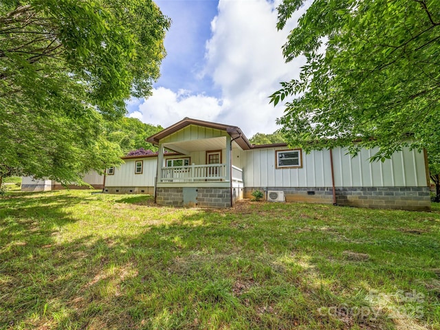74 Saturn Ct, Clyde, NC 28721 - rear view of house with crawl space, covered porch, board and batten siding, and a lawn