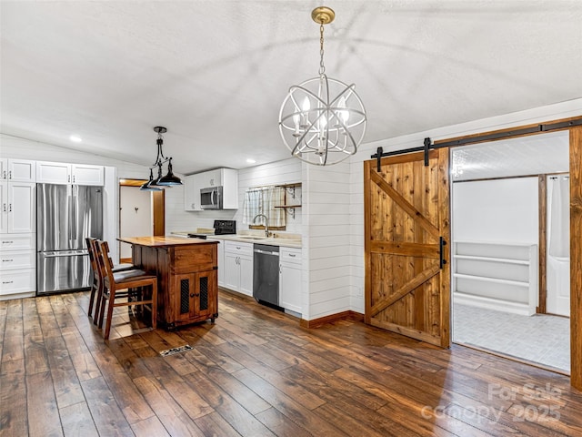 74 Saturn Ct, Clyde, NC 28721 - kitchen with stainless steel appliances, a barn door, a sink, a chandelier, and white cabinetry