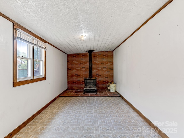 74 Saturn Ct, Clyde, NC 28721 - unfurnished living room with a wood stove, baseboards, an ornate ceiling, light flooring, and ornamental molding