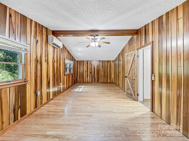 74 Saturn Ct, Clyde, NC 28721 - hall with wood walls, light wood-type flooring, a wall mounted air conditioner, and a textured ceiling