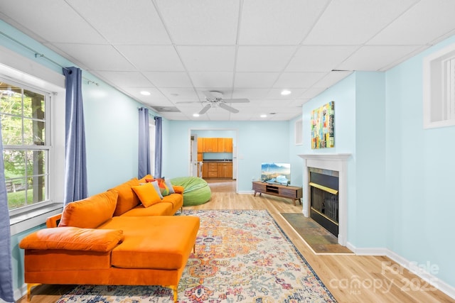 4120 Lake Shore Rd S, Denver, NC 28037 - living area with a ceiling fan, a tiled fireplace, wood finished floors, a drop ceiling, and baseboards