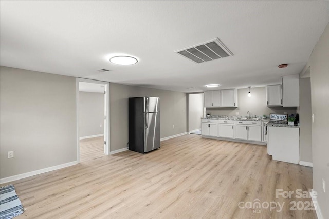 1746 2nd Street Pl SW, Hickory, NC 28602 - kitchen with freestanding refrigerator, light wood finished floors, baseboards, and open floor plan