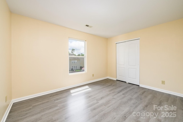 4521 Palustris Ct, Charlotte, NC 28269 - unfurnished bedroom featuring wood finished floors, baseboards, and a closet