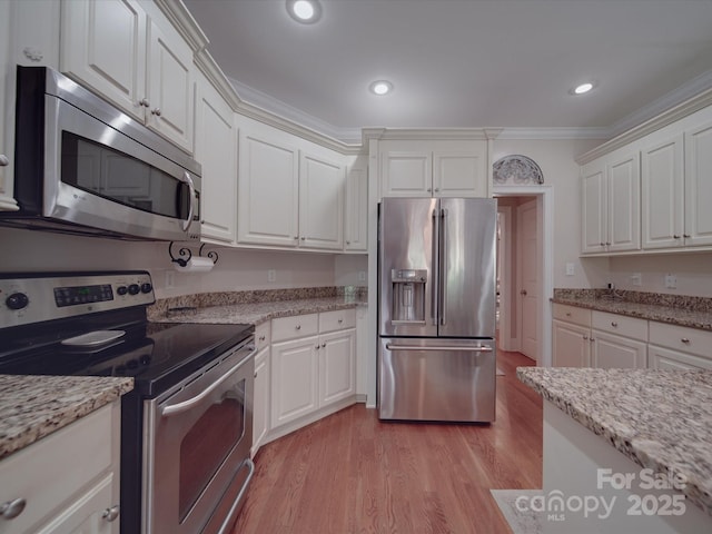 1508 Avalon Oaks Ct, Dallas, NC 28034 - kitchen featuring appliances with stainless steel finishes, light wood-type flooring, white cabinetry, ornamental molding, and light stone countertops