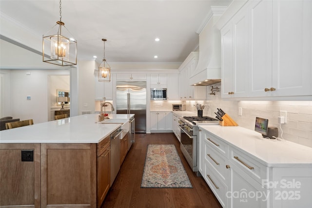 722 Clegg Farm Dr, York, SC 29745 - kitchen with built in appliances, tasteful backsplash, a center island with sink, dark wood-style floors, and crown molding