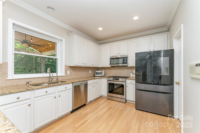 1147 Anduin Falls Dr, Charlotte, NC 28269 - kitchen with appliances with stainless steel finishes, a sink, white cabinets, light wood-style floors, and backsplash