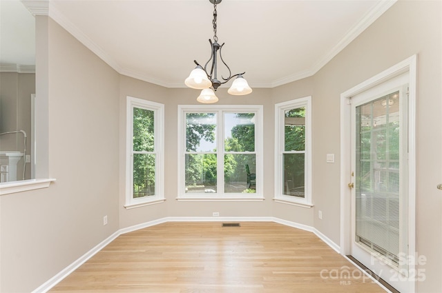 1147 Anduin Falls Dr, Charlotte, NC 28269 - unfurnished dining area with healthy amount of natural light, a chandelier, light wood finished floors, baseboards, and ornamental molding