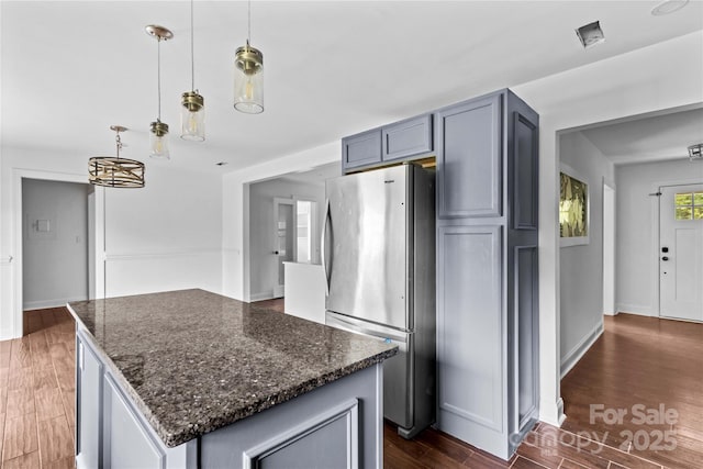 211 Ridgecrest St, Kannapolis, NC 28081 - kitchen featuring freestanding refrigerator, dark wood-style flooring, dark stone counters, a kitchen island, and pendant lighting
