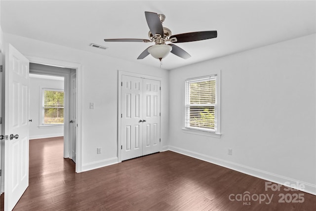 211 Ridgecrest St, Kannapolis, NC 28081 - unfurnished bedroom with dark wood-style flooring, baseboards, a closet, and ceiling fan