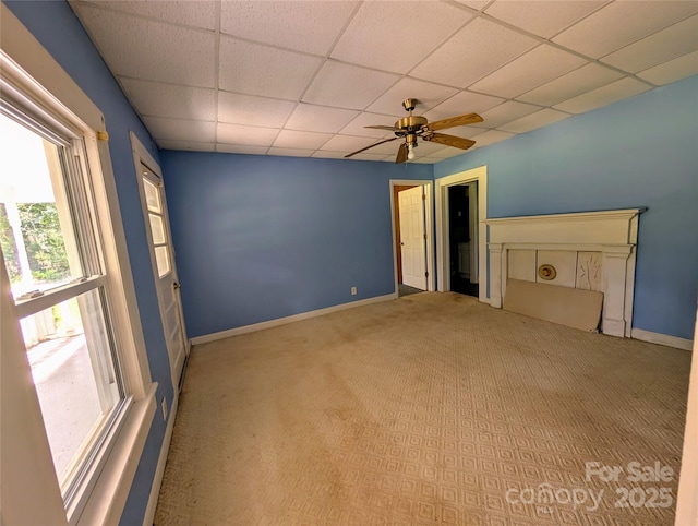 unfurnished room featuring a paneled ceiling, carpet floors, a ceiling fan, and baseboards