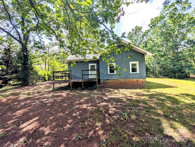 rear view of property featuring a deck, a yard, and crawl space