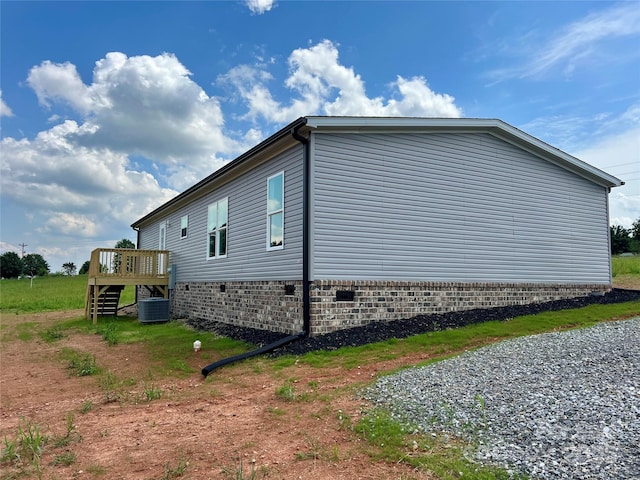 view of property exterior with a deck, crawl space, stairway, and central air condition unit