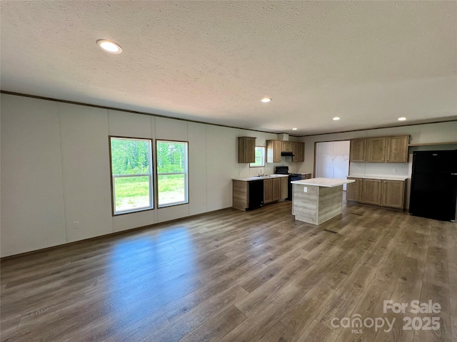 kitchen featuring freestanding refrigerator, dark wood-type flooring, light countertops, open floor plan, and a textured ceiling