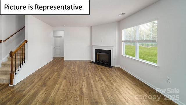 7729 Woolsey Dr, Gastonia, NC 28056 - unfurnished living room with wood finished floors, a fireplace, stairs, and baseboards