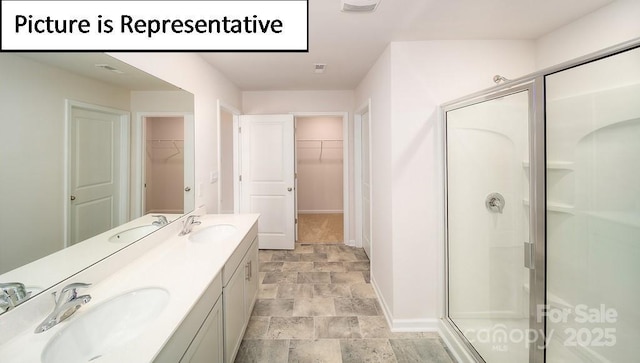 7729 Woolsey Dr, Gastonia, NC 28056 - bathroom with stone finish floors, a shower stall, double vanity, baseboards, and a spacious closet