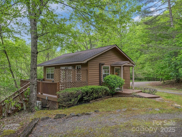 view of front of home featuring a wooden deck and a shingled roof