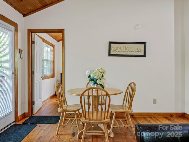 dining area featuring lofted ceiling, wood-type flooring, and baseboards