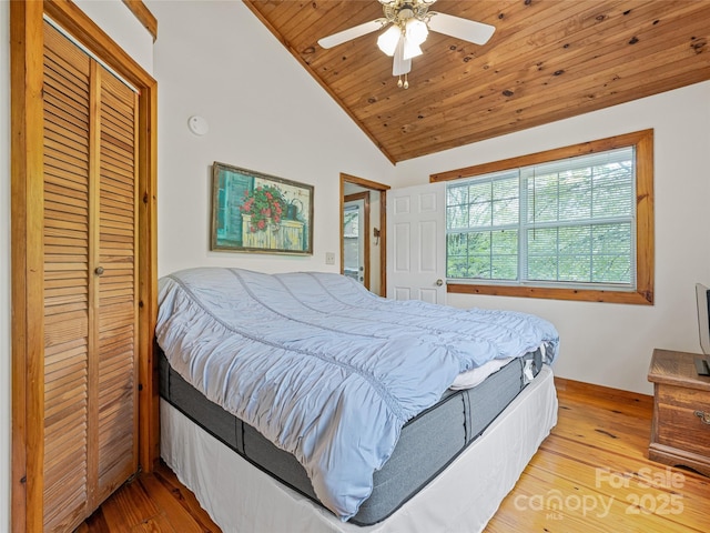 bedroom featuring vaulted ceiling, wood ceiling, wood finished floors, ceiling fan, and a closet