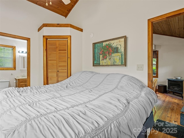 bedroom featuring wooden ceiling, vaulted ceiling, hardwood / wood-style flooring, connected bathroom, and a closet