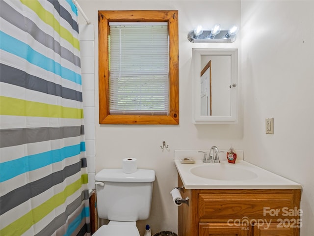 bathroom featuring toilet, vanity, and a shower with shower curtain
