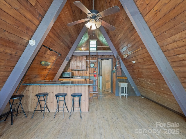 bonus room with wood ceiling, wood finished floors, wooden walls, and ceiling fan