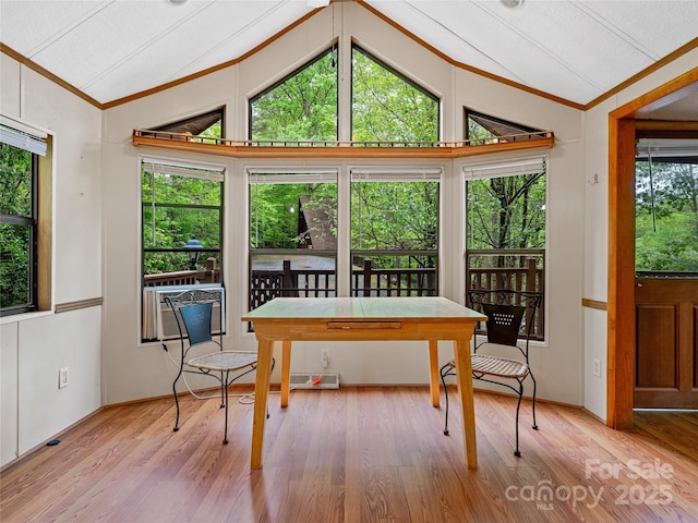 dining space with vaulted ceiling, wood finished floors, and ornamental molding