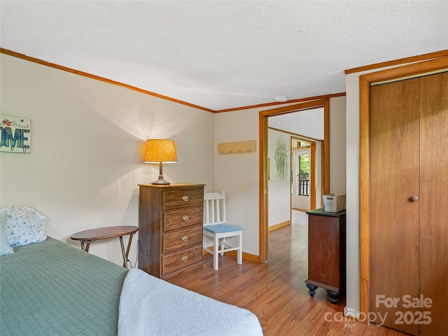 bedroom featuring wood finished floors, crown molding, and a textured ceiling