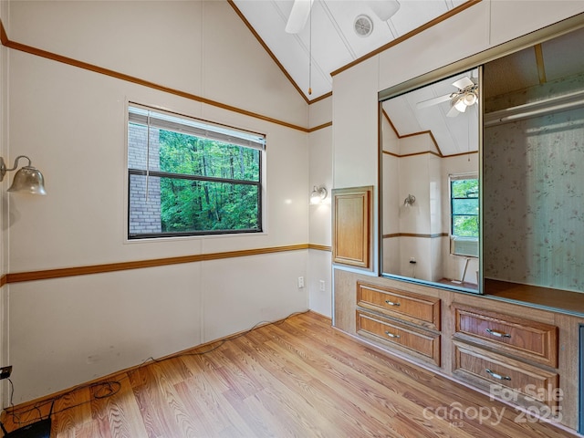 unfurnished bedroom featuring lofted ceiling and light wood-style flooring