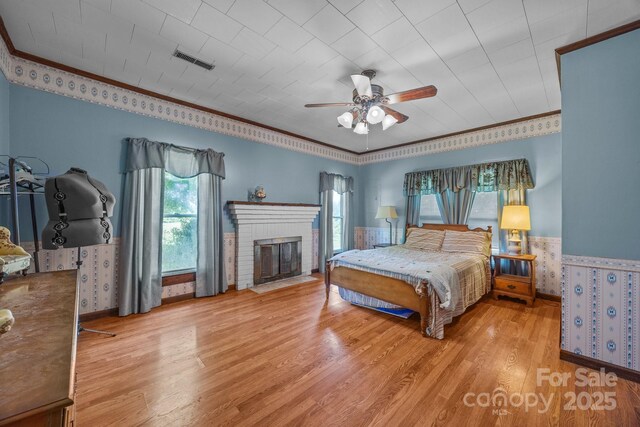 18070 Old Beatty Ford Rd, Gold Hill, NC 28071 - bedroom with wood finished floors, crown molding, baseboards, a brick fireplace, and a ceiling fan