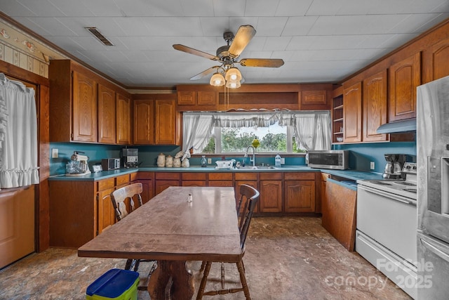 18070 Old Beatty Ford Rd, Gold Hill, NC 28071 - kitchen featuring brown cabinets, stainless steel appliances, a sink, under cabinet range hood, and a ceiling fan