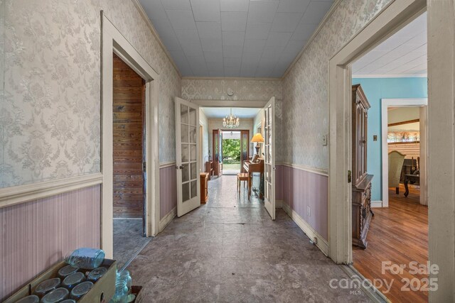 18070 Old Beatty Ford Rd, Gold Hill, NC 28071 - hallway featuring wallpapered walls, a chandelier, ornamental molding, a wainscoted wall, and baseboards