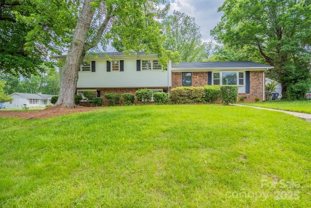 tri-level home with a front yard and brick siding