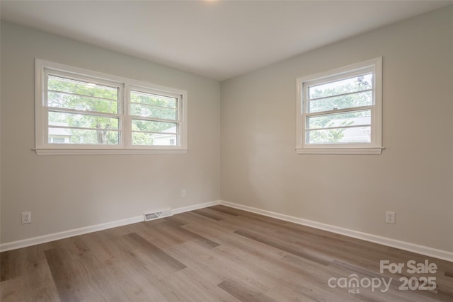 empty room with wood finished floors and baseboards