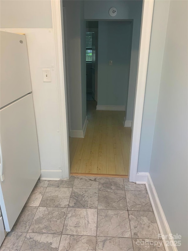 corridor with baseboards and light marble finish flooring