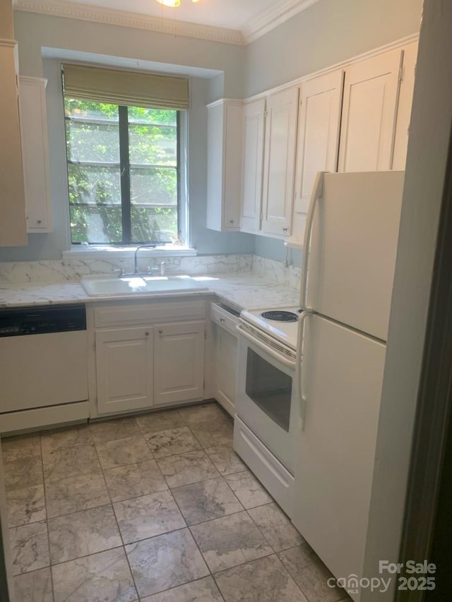 kitchen with white appliances, white cabinets, a sink, ornamental molding, and light stone counters