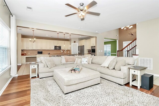 1618 Bay Meadows Ave NW, Concord, NC 28027 - living room with a chandelier, light wood-style floors, ceiling fan, and healthy amount of natural light